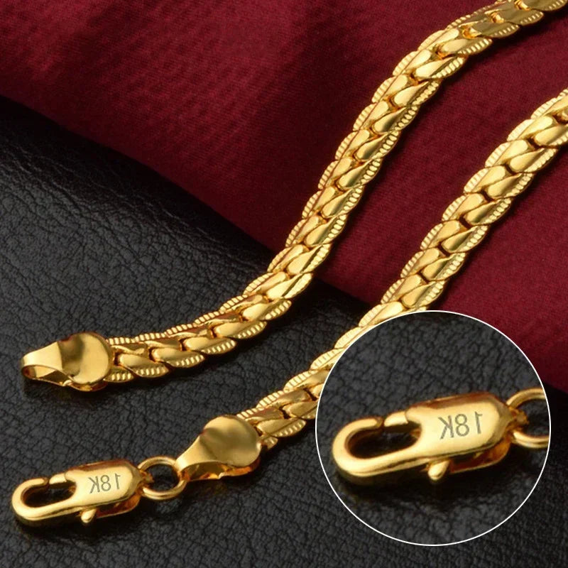 Close-up of 18K gold chain necklace with clasp on black and red fabric background