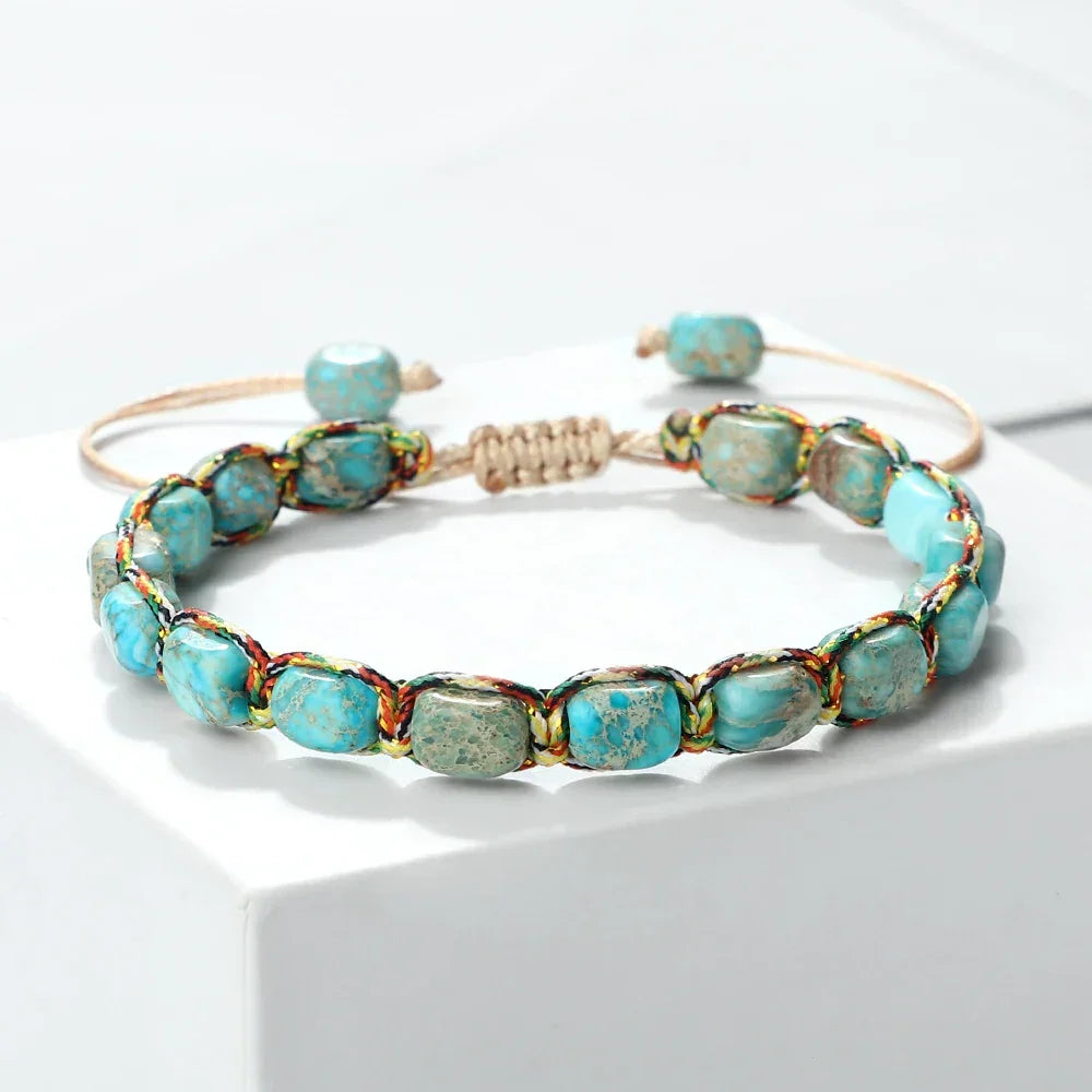 Handwoven bracelet with blue turquoise stone beads and multicolor thread on a white surface