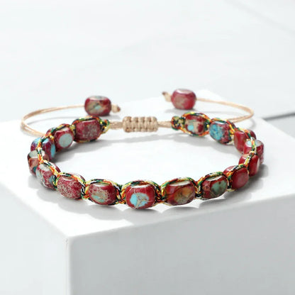 Adjustable bracelet with red and turquoise stone beads on a white platform