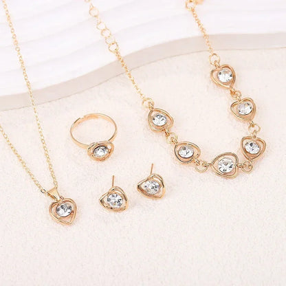 Gold-tone jewelry set with heart-shaped clear crystal pendant necklace, ring, earrings, and bracelet