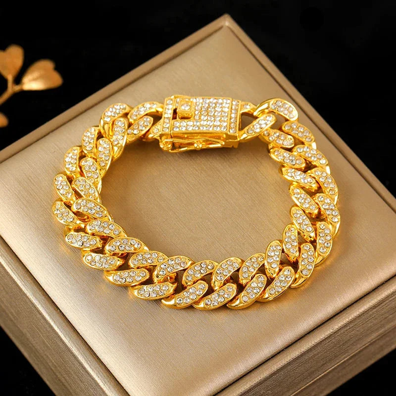 Gold Cuban link bracelet with embedded clear crystals displayed on beige jewelry box